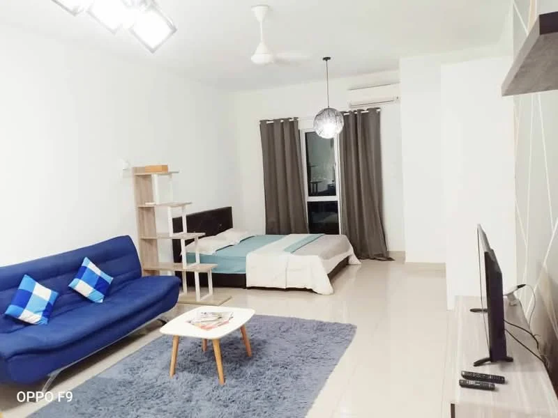 Living features: blue fabric sofa with cushions, white coffee table, area rug with geometric pattern, wall-mounted TV, ceiling fan, recessed downlights, curtains in grey, wooden shelving unit, bed with white bedding, floor-to-ceiling window; style: modern.