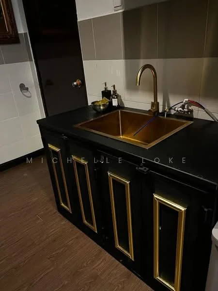 Kitchen features: black cabinetry with gold accents, gold sink, single-bowl sink, chrome faucet, countertop with dark finish, tile backsplash in neutral tones, wood flooring, wall-mounted cabinet, decorative wall art; style: modern.
