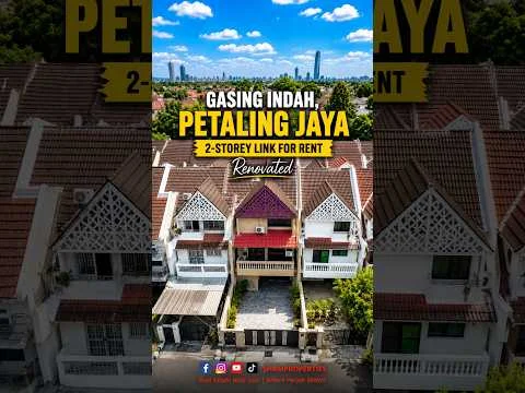 Exterior type: linked terrace house; features: 2-storey structure, renovated facade, white painted facade, decorative gable roof, red tiled roof, balconies on upper level, manicured landscaping, driveway, surrounded by greenery, urban context with skyline in background; style: modern.