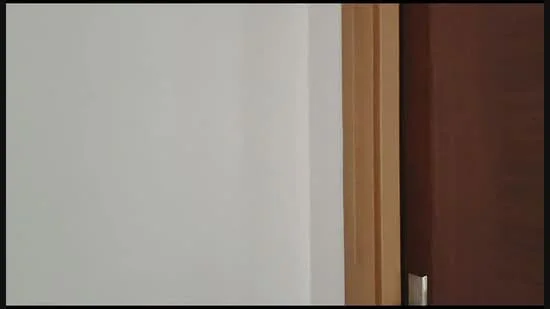 Room features: white painted walls, wooden door, metal door handle.