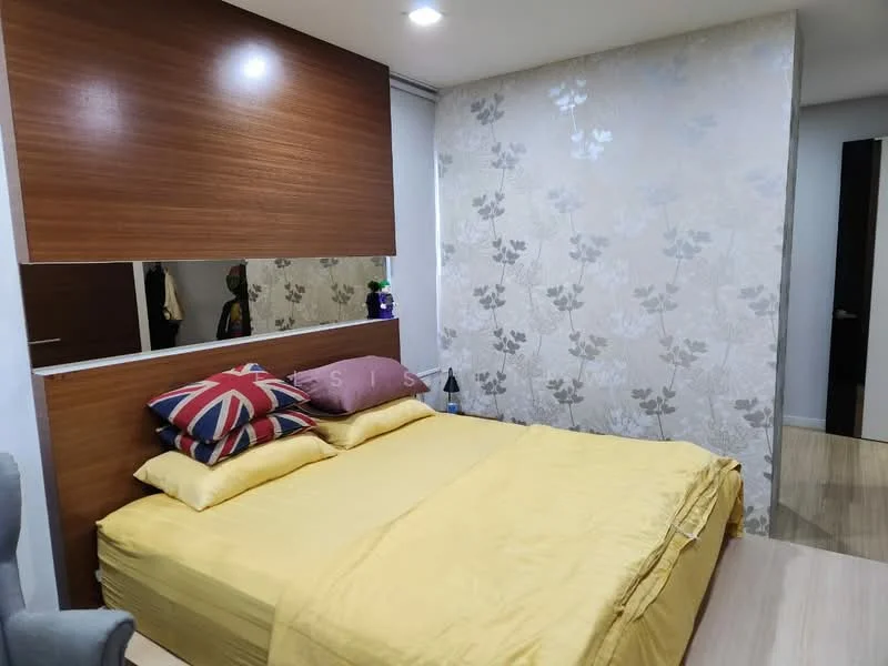 Bedroom features: queen-size bed with yellow bedding, upholstered headboard, decorative pillows with Union Jack design, wood panel accent wall, floral wallpaper, mirrored panel above the bed, laminate flooring, bedside table, table lamp, wardrobe in background; style: modern.