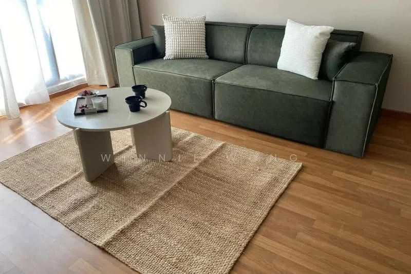 Living features: 3-seater fabric sofa in green, two white throw pillows, round coffee table in white, area rug in natural fiber, wooden flooring, floor-to-ceiling windows with sheer curtains, decorative magazine on the coffee table, ceramic cup on the coffee table; style: modern.