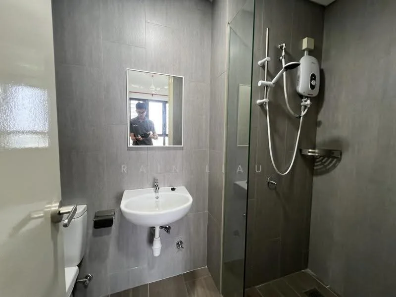 Bathroom features: grey tiled walls, grey tiled flooring, walk-in shower with glass enclosure, rain shower head, handheld shower, chrome basin mixer, white sink, toilet, mirror, shower heater, wall-mounted shelf; style: modern.