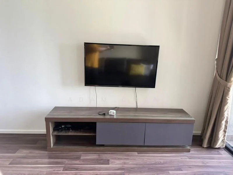 Living features: wall-mounted TV, wooden TV console with grey drawers, light-colored walls, laminate flooring, curtains, open space, natural light from window; style: modern.