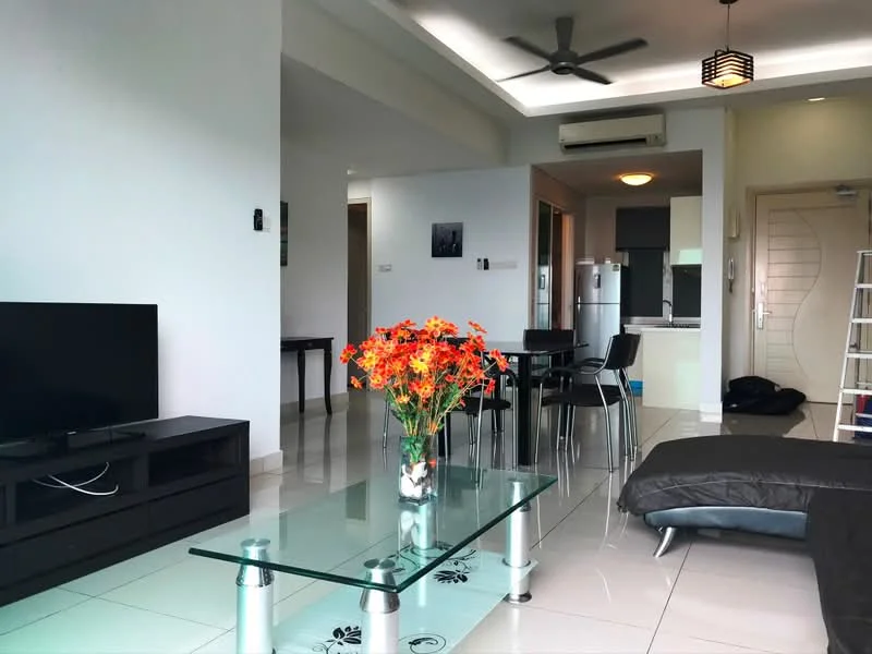 Living features: 3-seater black sofa, glass coffee table with floral design, flat-screen TV on black TV console, ceiling fan, recessed downlights, white painted walls, glossy tile flooring, decorative vase with flowers, open layout to kitchen, dining table with chairs visible in background; style: modern. Kitchen features: stainless-steel fridge, built-in kitchen cabinetry, open layout to living area; style: modern.