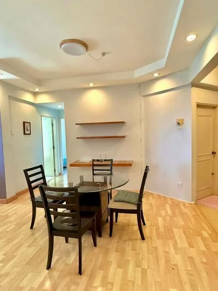 Dining features: round glass dining table, 4 black wooden dining chairs, light wood laminate flooring, white painted walls, recessed ceiling lights, ceiling light fixture, open shelving unit on wall, doorway leading to another room; style: modern.