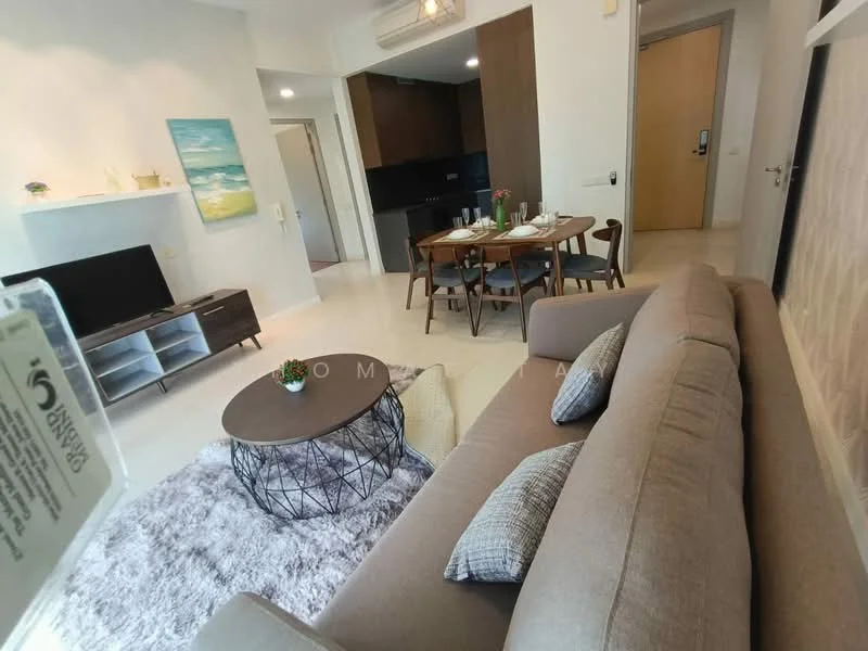 Living features: beige fabric sofa, round coffee table with black wire base, area rug with fluffy texture, wall-mounted TV, light wood TV console, dining table with four chairs, decorative vase on dining table, artwork on wall, recessed lighting, white painted walls, large window with natural light; style: modern.