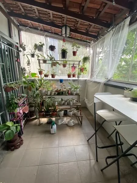 Balcony features: potted plants on shelves, hanging plants, white folding table, two white stools, tiled flooring, wooden ceiling, sheer curtains, greenery view; style: modern; view: garden.