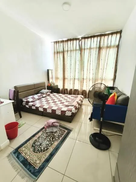 Bedroom features: queen-size bed with checkered bedding, floor-to-ceiling windows with sheer curtains, wall-mounted fan, ceramic tile flooring, decorative area rug with intricate pattern, white painted walls, small bedside table, blue sofa with cushions, red waste bin, clothing on the floor; style: minimalist.
