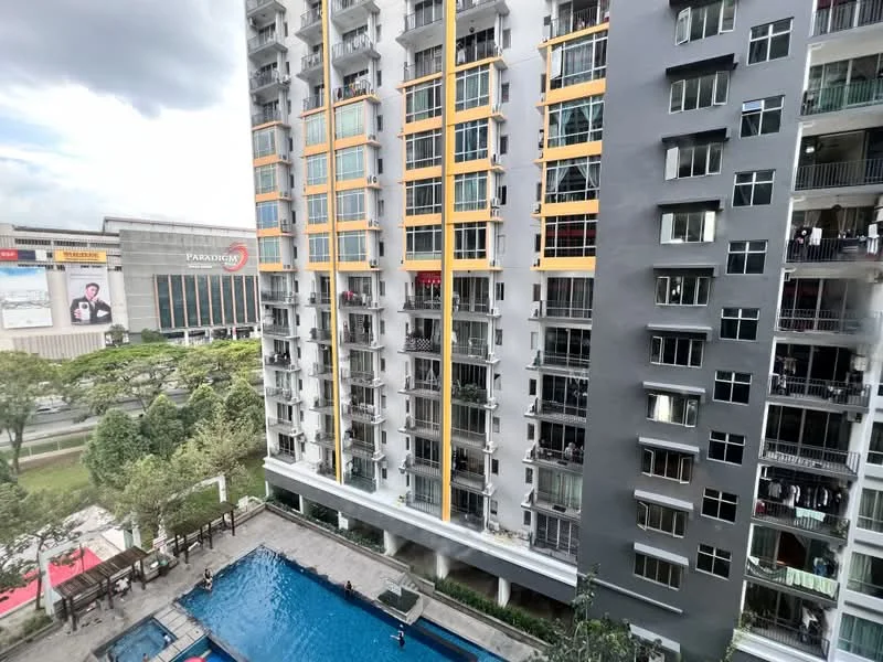 Exterior type: high-rise condominium; features: glass curtain wall, yellow accent panels, balconies with glass railings, swimming pool deck, landscaped garden area, surrounding greenery, adjacent commercial building, outdoor seating area by the pool; style: modern.