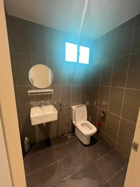 Bathroom features: grey tiled walls, black tiled flooring, round mirror, wall-mounted sink, chrome faucet, one-piece toilet, window for natural light, shower hose, towel rack; style: modern.
