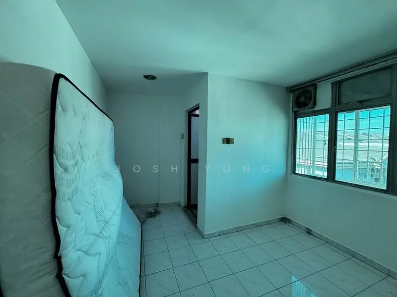 Room features: white painted walls, white tiled flooring, large windows with metal frames, window air conditioning unit, light fixture on ceiling, door to hallway, mattress leaning against wall.