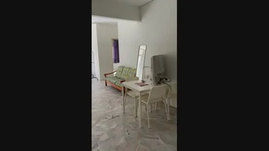 Room features: green and beige patterned sofa, mirror, white dining table, two white chairs, light-colored flooring, white painted walls, natural light from window, minimalist decor; style: minimalist.