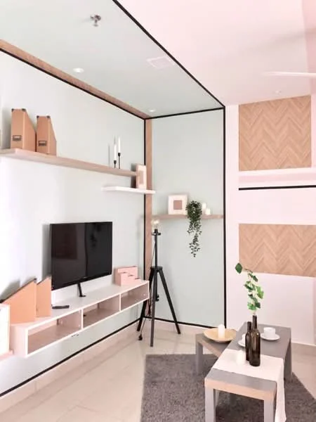 Living features: light grey wall, white wall with wooden shelves, wooden accent wall with herringbone pattern, flat-screen TV on wall-mounted console, decorative tripod stand, greenery in wall-mounted planter, grey area rug, coffee table, bottles on coffee table, candles on coffee table; style: modern.