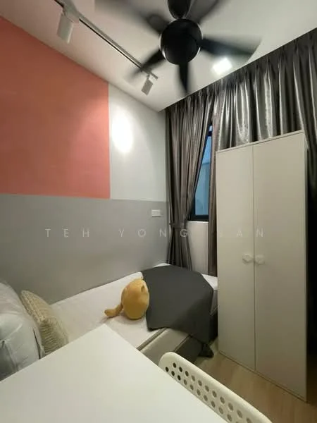 Bedroom features: single bed with grey bedding, white walls with pink accent wall, 5-blade ceiling fan, floor-to-ceiling window with sheer curtains, built-in wardrobe in white, wooden flooring, study desk with white chair, decorative teddy bear; style: modern.