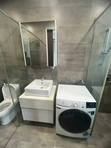Bathroom features: grey tiled walls, grey tiled flooring, single-sink vanity with white cabinet, square ceramic sink, chrome basin mixer faucet, framed mirror, one-piece toilet, glass shower enclosure, built-in shower shelf, front-load washing machine; style: modern.