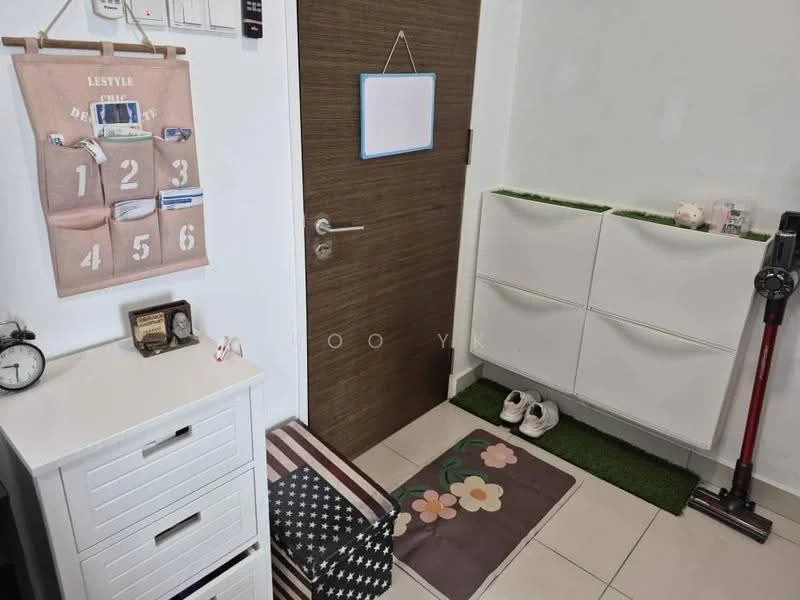 Room features: white painted walls, tile flooring, wooden door, shoe cabinet, decorative mat with floral pattern, wall-mounted organizer with pockets, clock, vacuum cleaner, small white side table, green grass-like mat; style: modern.