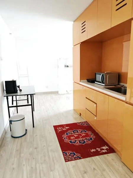 Kitchen features: orange cabinetry, built-in microwave, countertop with sink, single-bowl stainless-steel sink, chrome pull-down faucet, black countertop, table with black legs, white trash bin, red area rug with pattern, wood laminate flooring, white walls; style: modern.