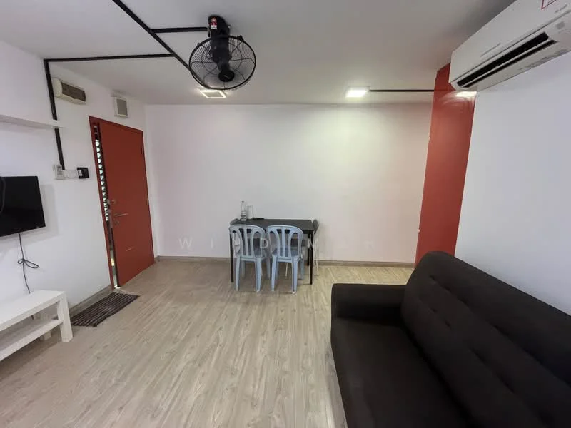 Living features: dark brown fabric sofa, 4-seater dining table with black tabletop, 4 plastic dining chairs in light blue, wall-mounted TV, wall-mounted split AC, light wood laminate flooring, white painted walls, red accent wall, ceiling fan with light, door with red finish; style: modern.