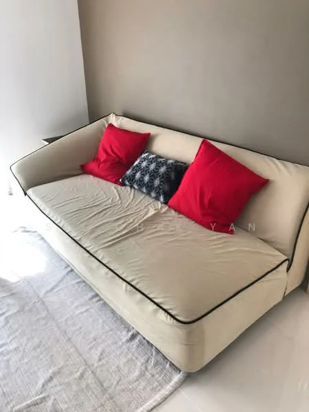 Living features: beige fabric sofa with black piping, two red accent pillows, grey area rug, white tiled flooring, plain beige walls, natural light from window; style: modern.