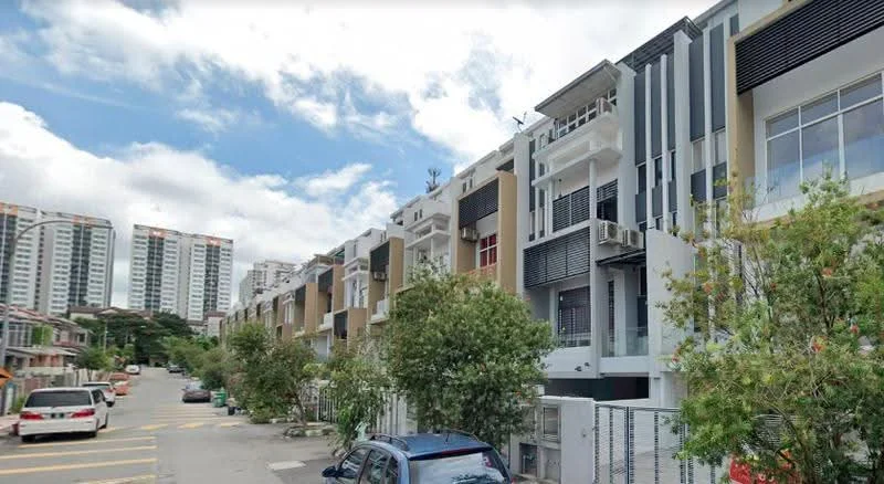 Exterior type: linked terrace house; features: two-storey linked terrace houses, cream painted facade, grey accent panels, balconies with glass railings, air conditioning units visible, manicured landscaping with small trees, paved driveway, surrounded by residential buildings, clear blue sky, urban context with nearby high-rise buildings; style: modern.