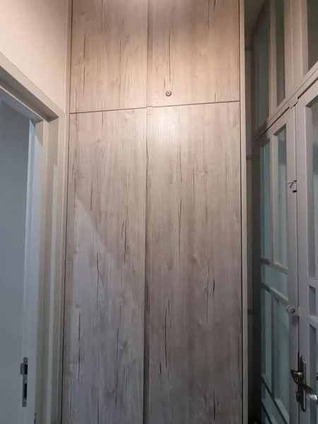 Room features: wooden cabinetry with textured finish, light wood colour, built-in storage, smooth surface, minimalist design; style: modern.