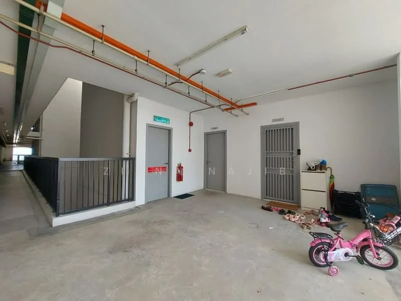 Room features: concrete flooring, white painted walls, fire extinguisher mounted on wall, two doors with security grilles, open space, visible children's bicycle, storage cabinet, scattered children's toys.
