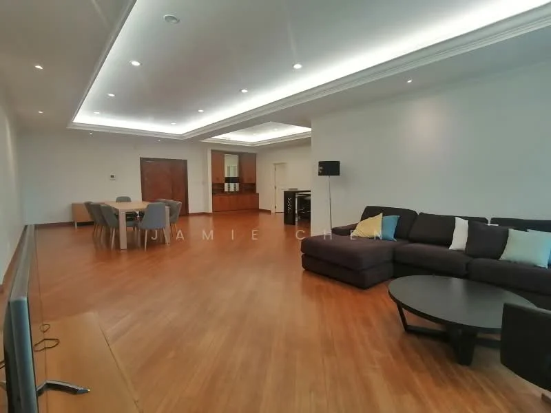 Living features: wooden flooring, white painted walls, tray ceiling with recessed lighting, large sectional sofa in dark fabric, coffee table, TV console, wall-mounted TV, dining table with chairs visible in background, double doors leading to another room, decorative cushions in light colors; style: modern.