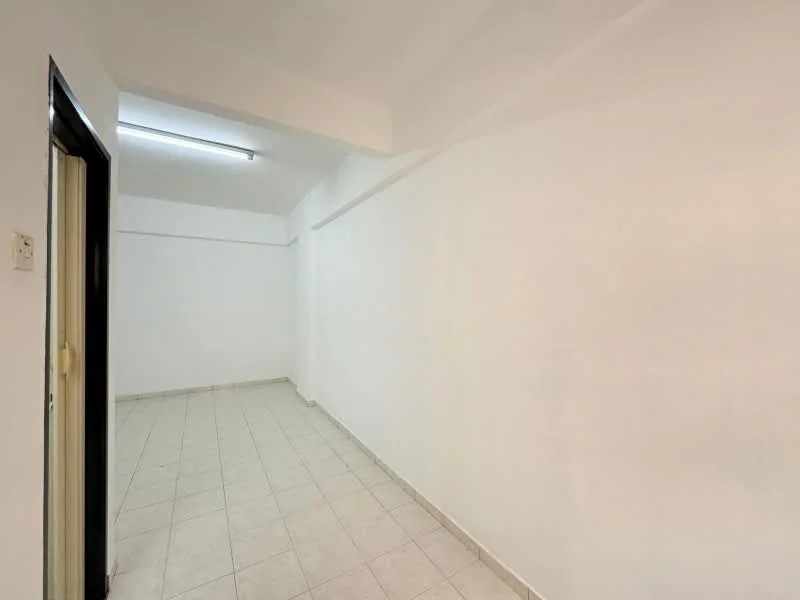 Room features: white painted walls, tile flooring, fluorescent ceiling light, empty space.