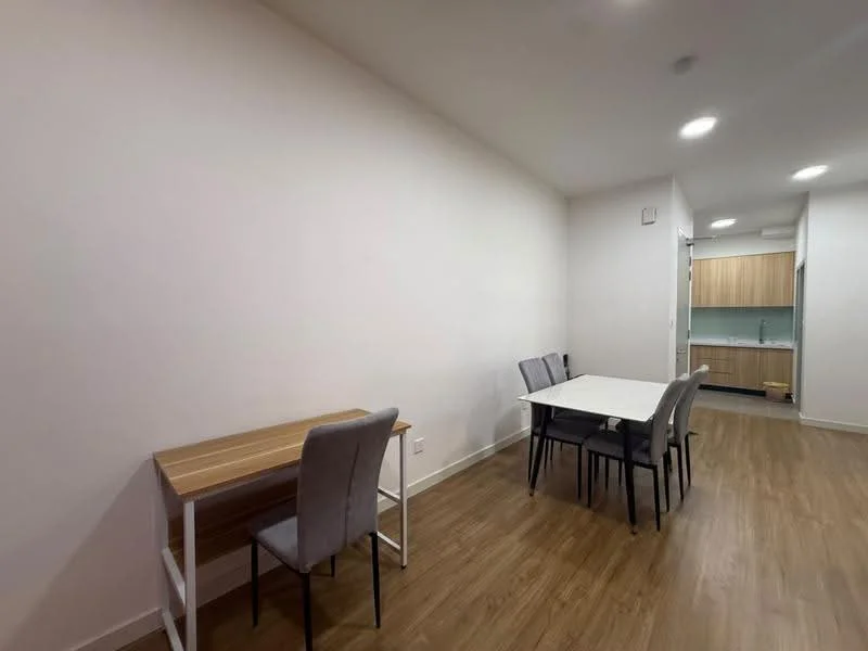 Dining features: light wood dining table, 4 grey upholstered dining chairs, white walls, laminate wood flooring, recessed downlights, open layout to kitchen, window view to kitchen area; style: modern. Room features: light wood desk, grey chair, white walls, laminate wood flooring, recessed downlights.
