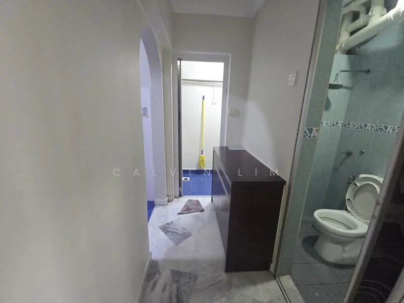 Room features: white painted walls, marble flooring, toilet, shower area with glass enclosure, blue tiled walls, wooden cabinet, floor drain, light fixture.