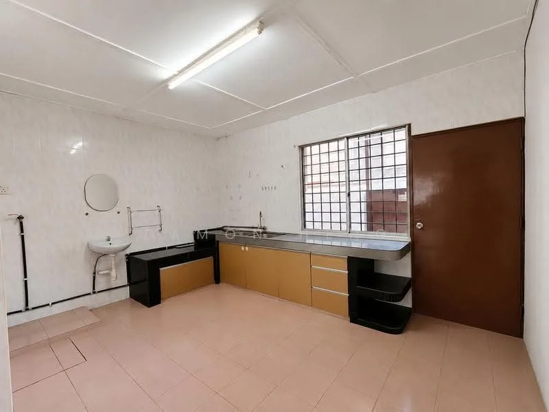 Room features: white painted walls, tile flooring, single-bowl sink, chrome faucet, long countertop with storage cabinets, built-in cabinetry, window with grid pattern, door with brown finish, fluorescent ceiling lights, mirror on wall, plumbing fixtures visible.