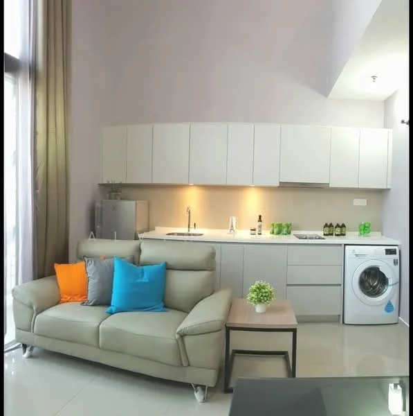 Living features: light grey leather sofa, orange and blue decorative cushions, coffee table with black surface, kitchenette with white cabinets, white countertop, stainless-steel sink, built-in stove, refrigerator, front-load washing machine, wall-mounted cabinets, neutral painted walls, large windows with natural light, glossy tile flooring; style: modern.