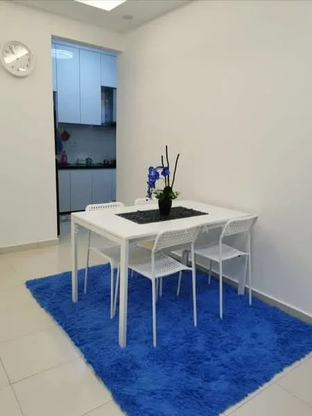 Dining features: white dining table, 4 white dining chairs, blue area rug, wall clock, white painted walls, tile flooring, potted plant with blue flowers, kitchen visible in background; style: modern.