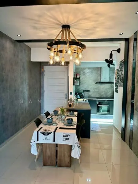 Dining features: rectangular dining table with white tablecloth, black dining chairs, chandelier with exposed bulbs, grey accent wall, white walls, polished tile flooring, kitchen island with bar stools, kitchen area visible in background, recessed lighting, open layout; style: modern.