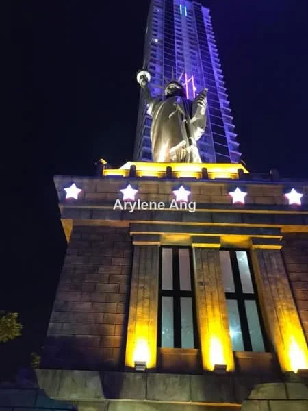 Exterior type: high-rise condominium; features: illuminated facade, statue of liberty replica, stone cladding, large windows, decorative lighting, multiple storeys, modern architectural design; style: modern.