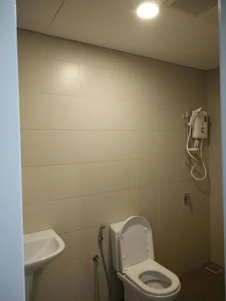 Bathroom features: white wall tiles, light beige floor tiles, one-piece toilet, handheld shower, wall-mounted shower head, sink with faucet, ceiling light, drain on floor; style: modern.