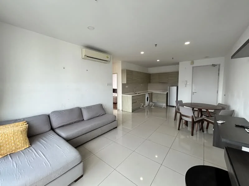 Living features: grey fabric L-shape sectional sofa, yellow decorative cushion, white painted walls, glossy white tile flooring, recessed downlights, wall-mounted split AC, dining table with four chairs, black study desk, fridge, kitchen cabinetry with light wood finish, open kitchen layout; style: modern.