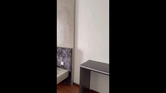 Room features: light-colored painted walls, wood flooring, dark accent wall, simple desk, minimalist decor; style: modern.