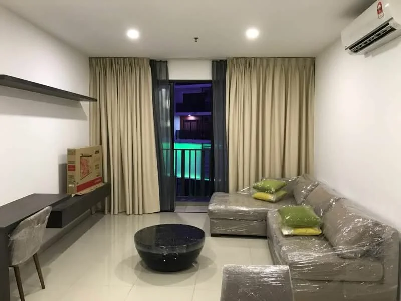 Living features: grey fabric sectional sofa, black round coffee table, wall-mounted TV console, floor-to-ceiling windows, sheer curtains, blackout curtains, air conditioning unit, light-colored tiled flooring, decorative cushions in green, packaging wrap on furniture; style: modern; view: pool.