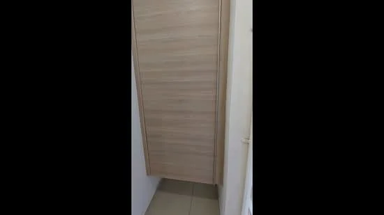 Room features: wooden door, light wood finish, tile flooring, neutral wall color.