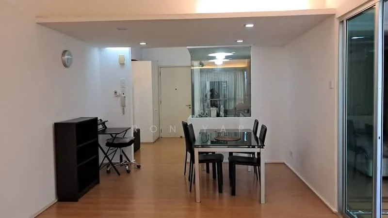 Dining features: wooden flooring, white painted walls, recessed downlights, glass dining table, black dining chairs, black bookshelf, wall clock, open layout; style: modern. Room features: white painted walls, wooden flooring, recessed downlights.