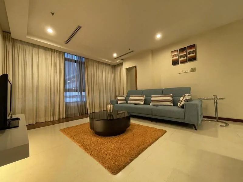 Living features: 3-seater fabric sofa in light blue, striped throw pillows, round coffee table with black surface, area rug in orange, floor-to-ceiling windows with sheer curtains, recessed downlights, wall-mounted TV console, decorative wall art, cream painted walls, light-colored flooring; style: modern; view: city.
