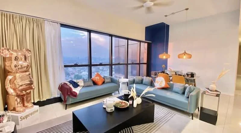 Living features: floor-to-ceiling windows, blue accent wall, 3-seater fabric sofa in light blue, 2-seater fabric sofa in light blue, black coffee table, pendant lighting, decorative cushions with patterns, area rug with geometric pattern, wall-mounted decor, ceiling fan, curtains in light fabric, decorative vase with flowers; style: modern; view: city.