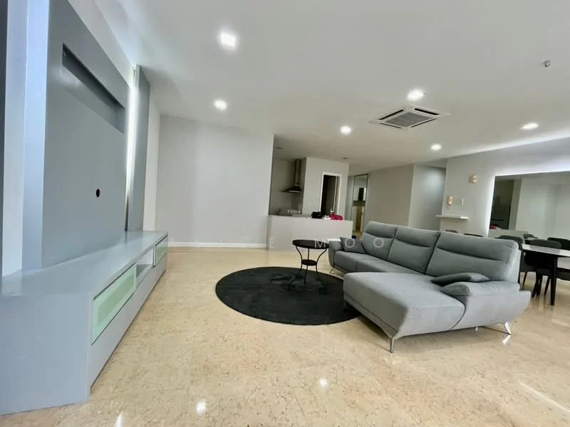 Living features: grey L-shape sectional sofa, black area rug, wall-mounted TV unit with storage, recessed LED downlights, marble flooring, open layout to kitchen, dining area visible in background, air conditioning unit; style: modern. Kitchen features: kitchen island, stainless-steel appliances, open layout to living area; style: modern.