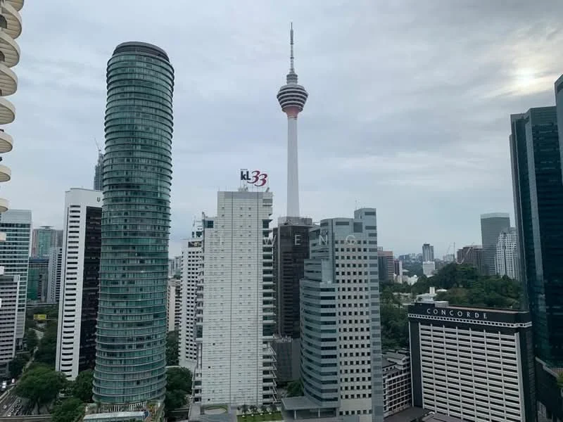 Exterior type: high-rise condominium; features: glass curtain wall, surrounded by city skyline, visible telecommunications tower, modern architectural design, adjacent to other high-rise buildings, urban landscape, greenery in the foreground; style: modern.