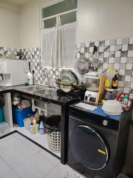 Kitchen features: black granite countertop, stainless-steel sink, chrome pull-down faucet, black washing machine, white painted walls, checkerboard tile backsplash, white ceramic tile flooring, window with sheer curtains, various cleaning supplies, plastic storage bins, metal cookware, dish rack, bottle of cooking oil, condiment bottles; style: modern.