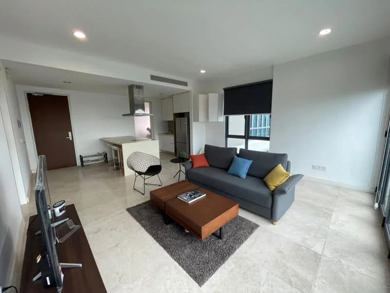 Living features: 3-seater fabric sofa in grey, decorative cushions in blue, yellow, and red, wood coffee table, area rug in dark grey, wall-mounted TV, TV console, floor-to-ceiling windows, sliding glass door, recessed downlights, marble tile flooring, open-plan layout to kitchen, black wire chair; style: modern; view: city. Kitchen features: kitchen island with seating, stainless-steel fridge, built-in oven, ceramic cooktop, white cabinetry, grey countertops, exhaust hood, open shelving; style: modern.