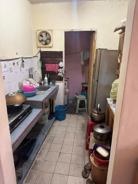 Kitchen features: grey laminate countertop, white tiled backsplash, stainless-steel fridge, gas stove with 4 burners, exhaust fan, ceramic tile flooring, wooden cabinetry, sink, plastic bucket, cooking pot, kitchen utensils, wall-mounted shelves.