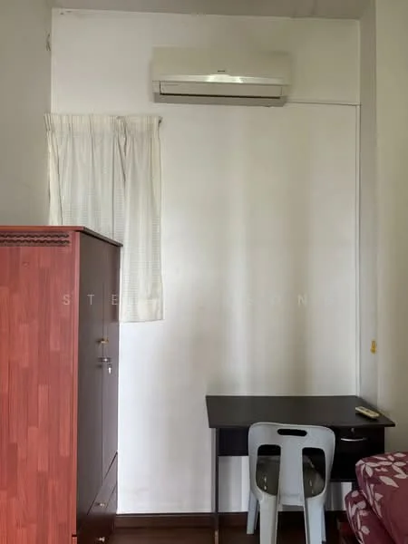 Room features: white painted walls, wooden flooring, 1 wall-mounted split AC, small black desk, plastic chair, curtains, wooden cabinet.